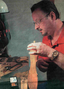 Gerry uses an electronic tuner to test this violin part!